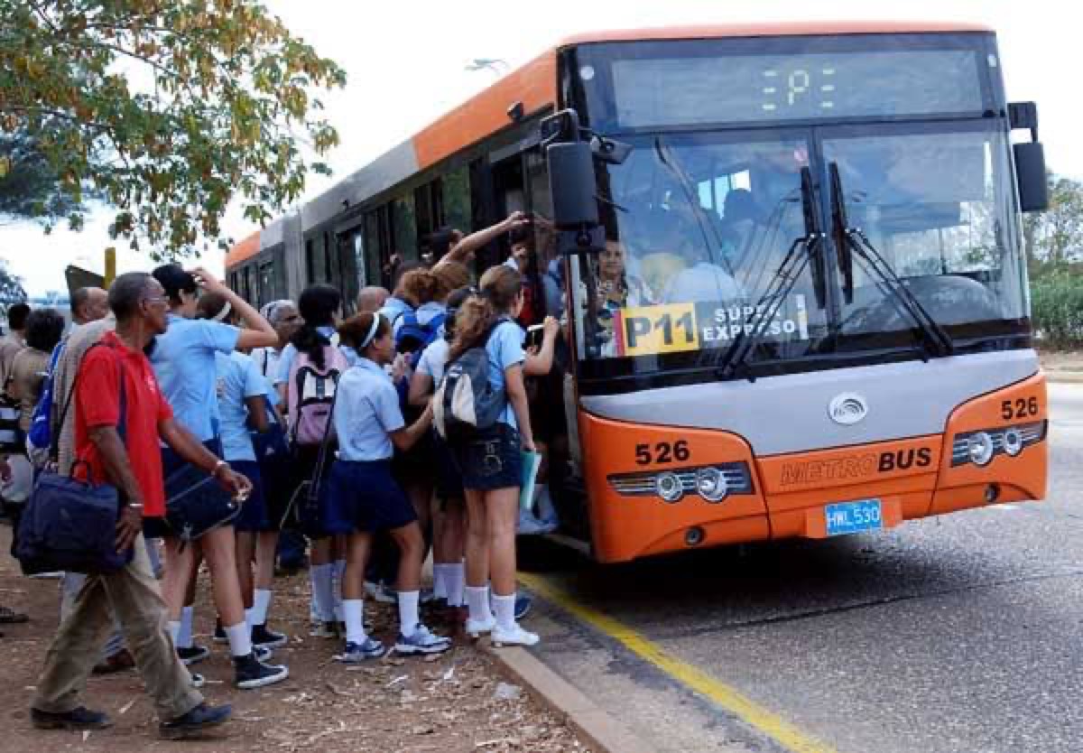 Studenti si accalcano su uno dei pochi autobus in servizio. L'Avana, metrobus P11.